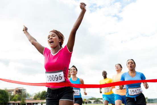 woman running and crossing finish line