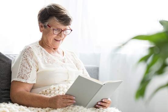 woman sitting in hospital-like setting reading a book