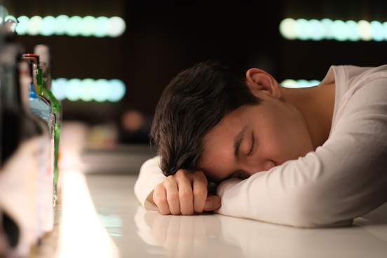 young man asleep on a bar