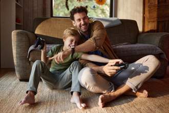 father and son having fun while playing video games in the living room