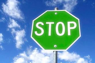 A green colored stop sign