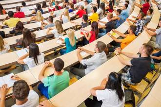 Rear view of large group students sitting in their first class at university