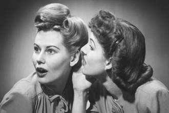 a black and white image of two women gossiping with each other