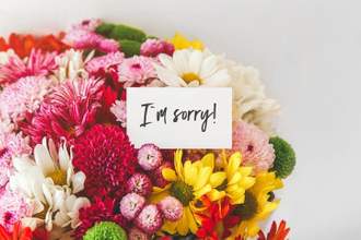 a bouquet of flowers with an im sorry card