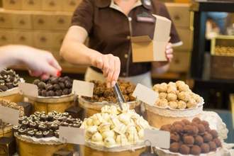 a buyer choosing candy and the seller putting the candy in the box