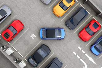a car pulls into the one open space in a full parking lot