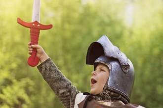 a child in armor raising their sword in the air