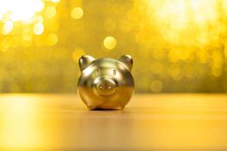 a gold piggy bank in front of a yellow and gold background