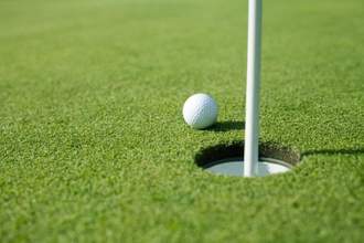 a golf ball sitting just beside the hole