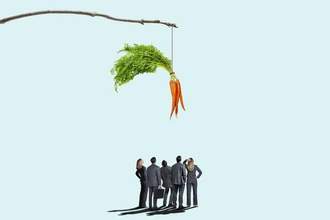 a group of business people looking up at large dangling carrots on a stick
