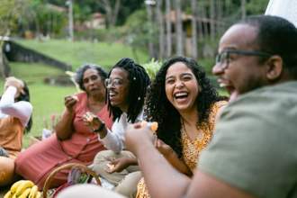 a group of friends laughing snacking and having a good time together