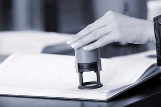 a hand stamping a paper