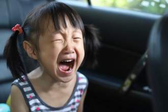 a little girl crying in the car