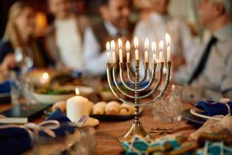 a menorah sitting on a table surrounded by family and friends