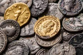 a pile of coins with two gold pieces sitting at the top