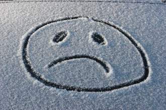 a sad face drawn in the snow