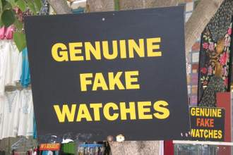 a sign hanging in front of a shop saying genuine fake watches