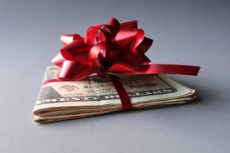 a stack of cash wrapped in a red ribbon