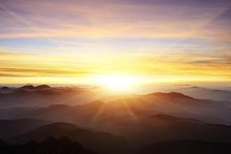 a sunrise coming up over a mountain range