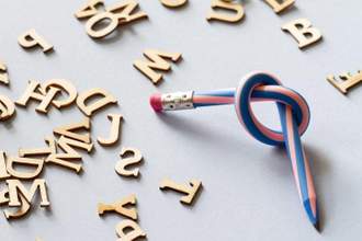 a twisted pencil with scattered wooden letters