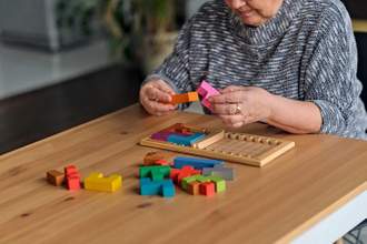 a woman sitting at a table working on a memory game