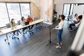 a woman standing in front of judges for an audition