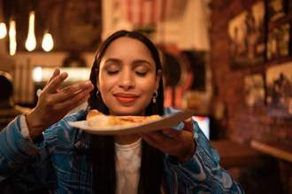 a woman wafting the smell of her food towards her nose