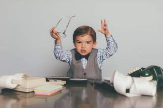 a young business man looking displeased with his hands thrown up in the air