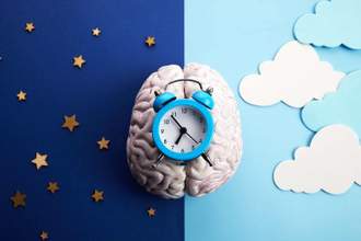 an alarm clock sitting on top of a brain with the day and night background
