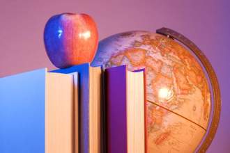 an apple sitting on top of books with the world globe sitting behind it