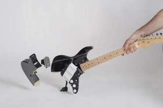 an arm smashing a guitar on the ground