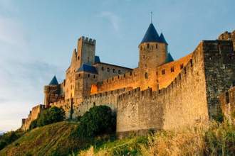 an upward view of an old castle built on a hill