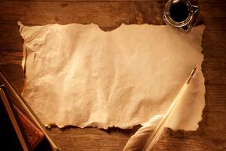antique paper on a wooden desk with a quill and ink
