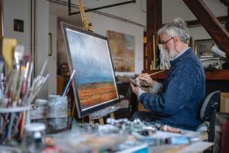 artist focusing on their painting while working in an art studio