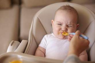 baby closing their mouth so that they dont have to eat the food being given to them