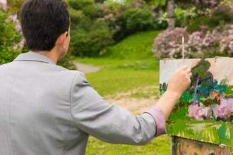 back view of a male artist working on an en plein air piece