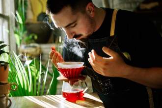 barista smelling coffee while making it