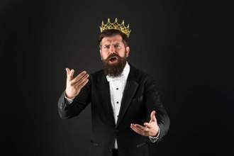bearded man with a crown making a grand speech