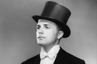 black and white image of a man wearing tuxedo and top hat