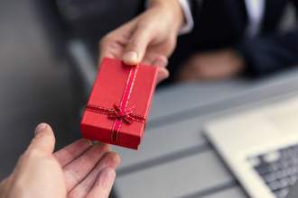 boss giving present gift box to office colleague