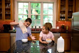 boy complaining that his sister ate the last of the cereal