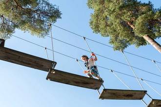 brave young girl crossing a high rope obstacle course