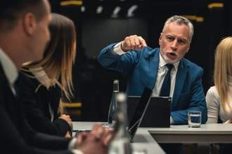 business man talking and pointing accusingly at coworkers