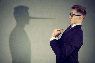 businessman pointing confused at himself while his shadow with a lying extended nose looks directly at him