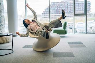 businesswoman falling off office chair in accidental moment