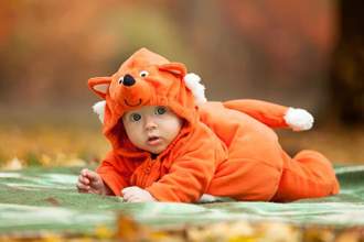 child dressed in a fox onsie