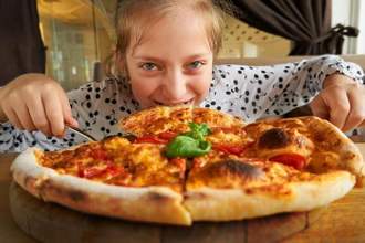 child hunched over pizza not wanting to share