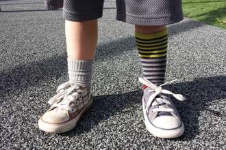 child wearing two different socks and shoes