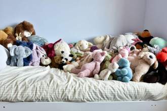 childs bedroom with plush toys crowding the bed
