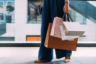close up of a woman holding several bags in one hand